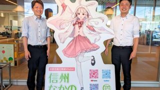 パネルの側に立つ二人の写真